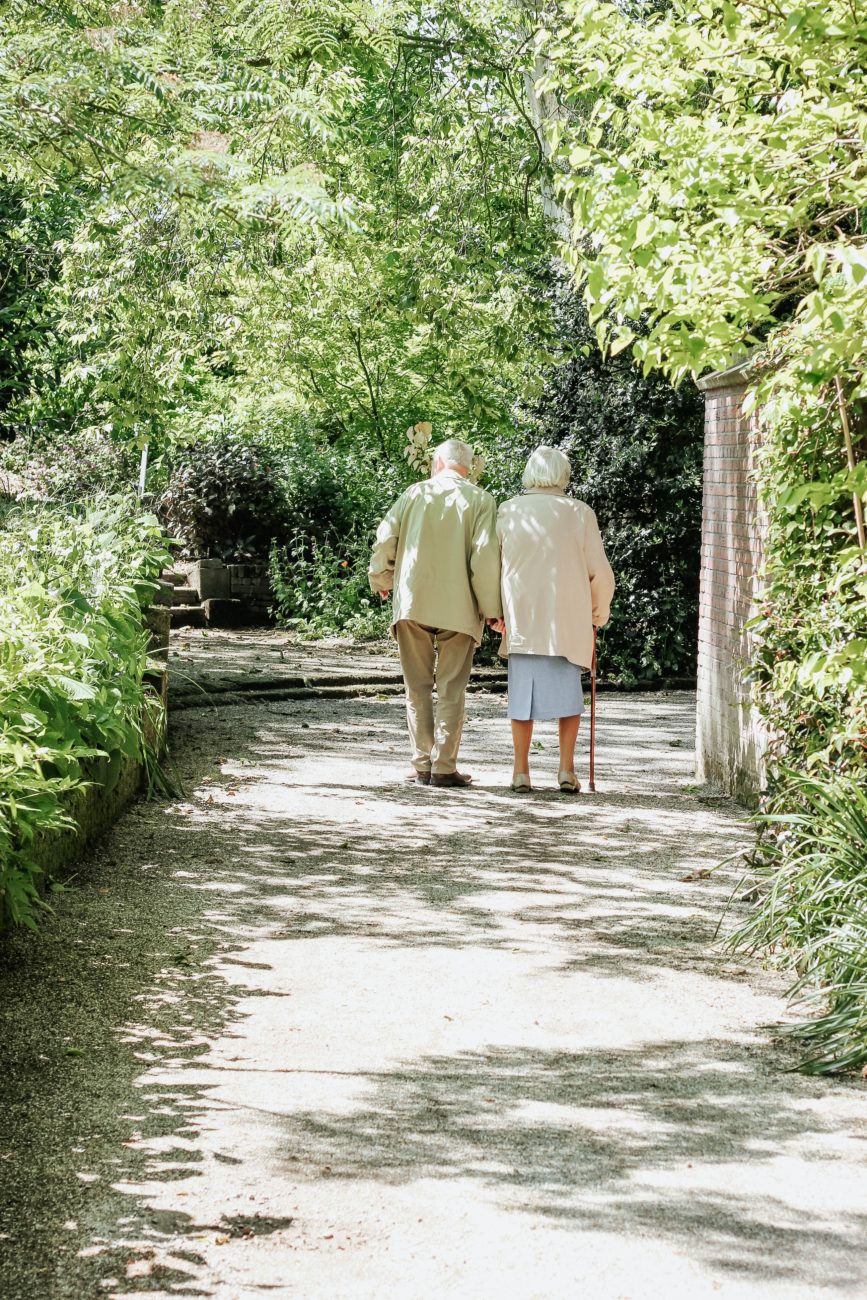 Elderly couple taking a walk through the park.